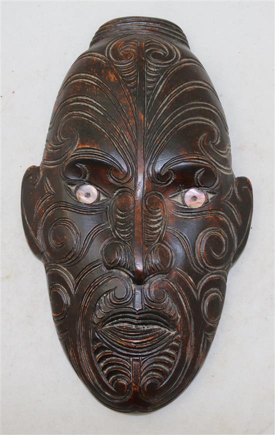 A mother of pearl inset carved hardwood Maori wall mask, 13in.